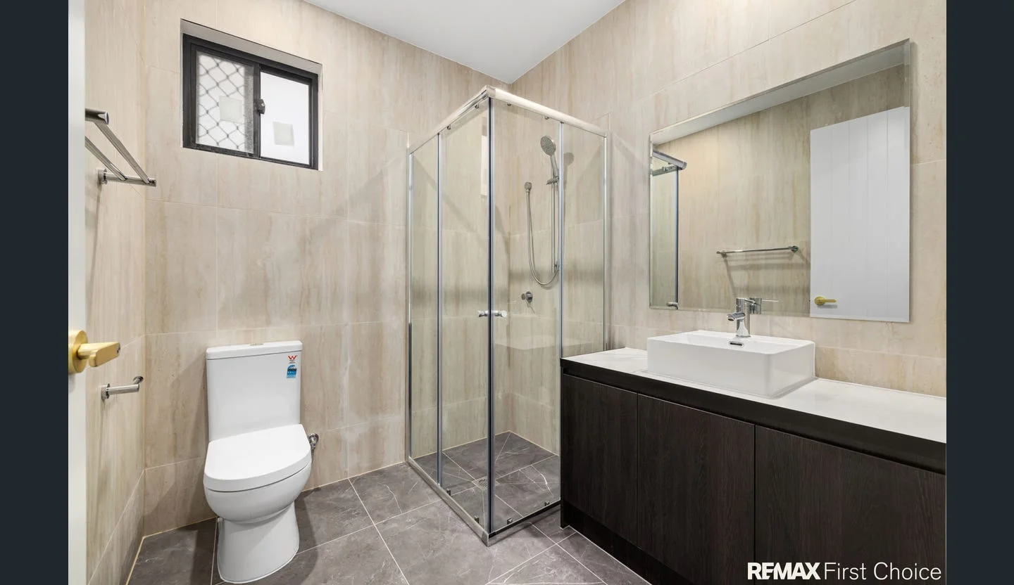 Completed tiled bathroom with glass shower enclosure
